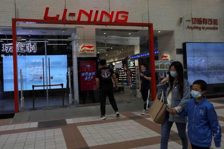People walking past a Li Ning store in Beijing, reflecting China's economic recovery - Global Banking & Finance Review