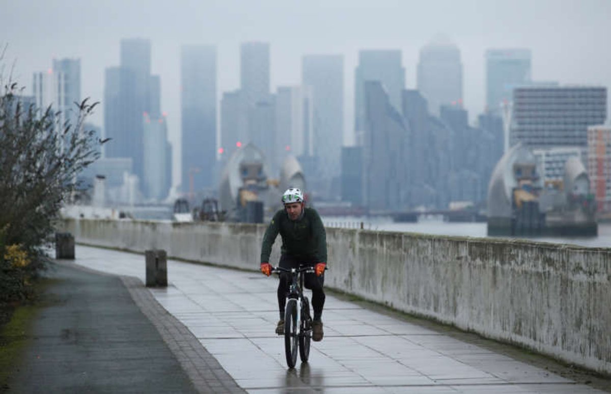 A cyclist passes through Canary Wharf, reflecting London’s finance landscape amidst EU deal discussions - Global Banking & Finance Review