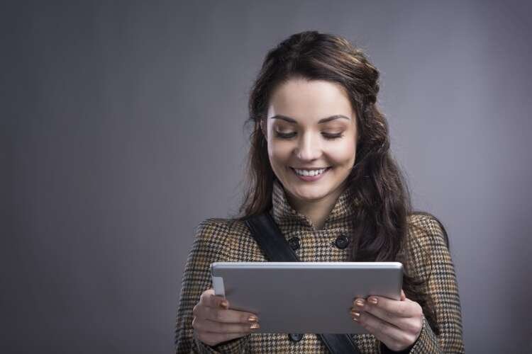 A professional woman using a tablet, representing growth in digital partnerships - Global Banking & Finance Review