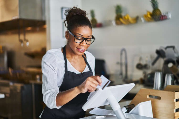 Waitress processing payment with a bank card on a POS terminal - Global Banking & Finance Review