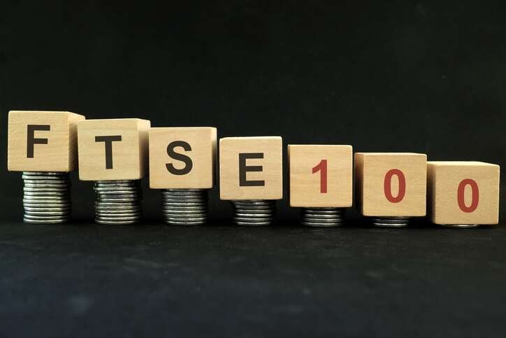 Wooden blocks and coins symbolizing low-cost FTSE 100 stocks after market downturn - Global Banking & Finance Review