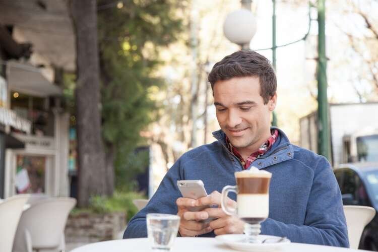 Man engaging with mobile banking technology in urban setting - Global Banking & Finance Review