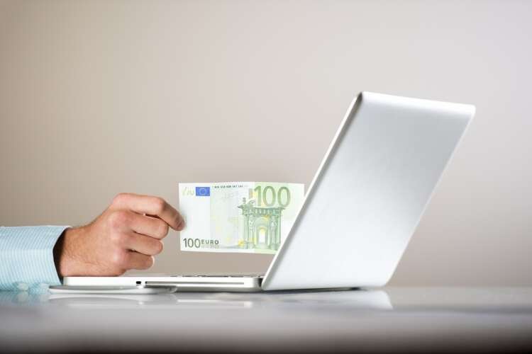 Businessman working with laptop and money, reflecting El Salvador's Bitcoin Law - Global Banking & Finance Review