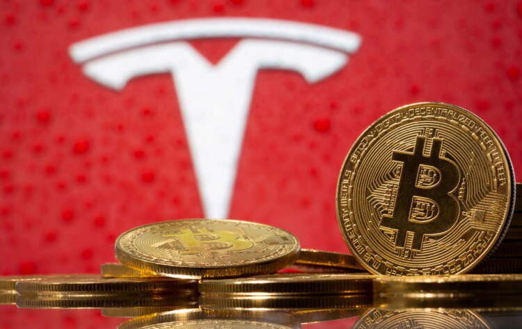 FILE PHOTO: Representations of virtual currency bitcoin are seen in front of Tesla logo in this illustration