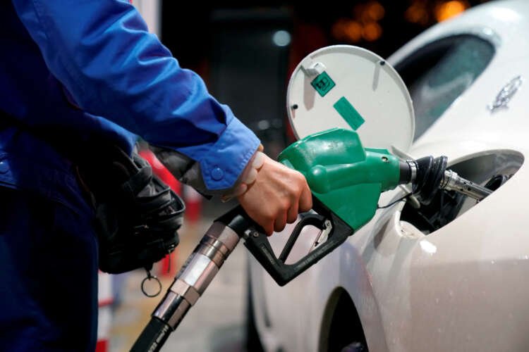Gas station attendant refueling a vehicle amidst rising oil prices - Global Banking & Finance Review