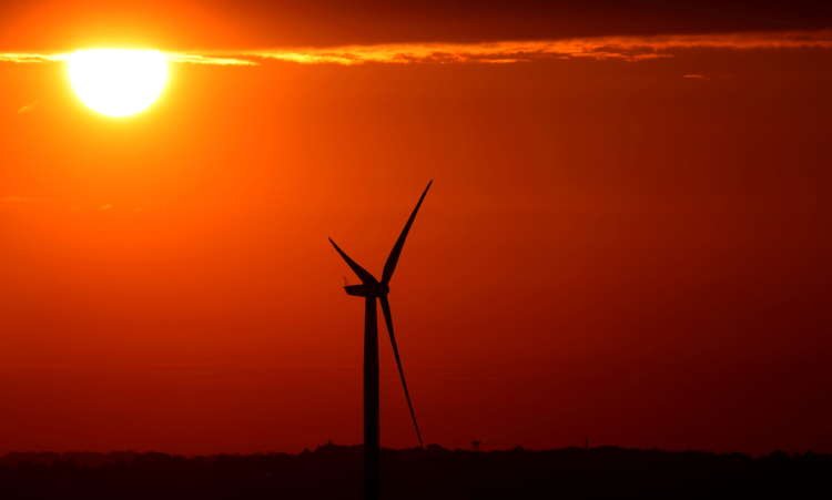 FILE PHOTO: The sun rises behind a wind mill in Halle