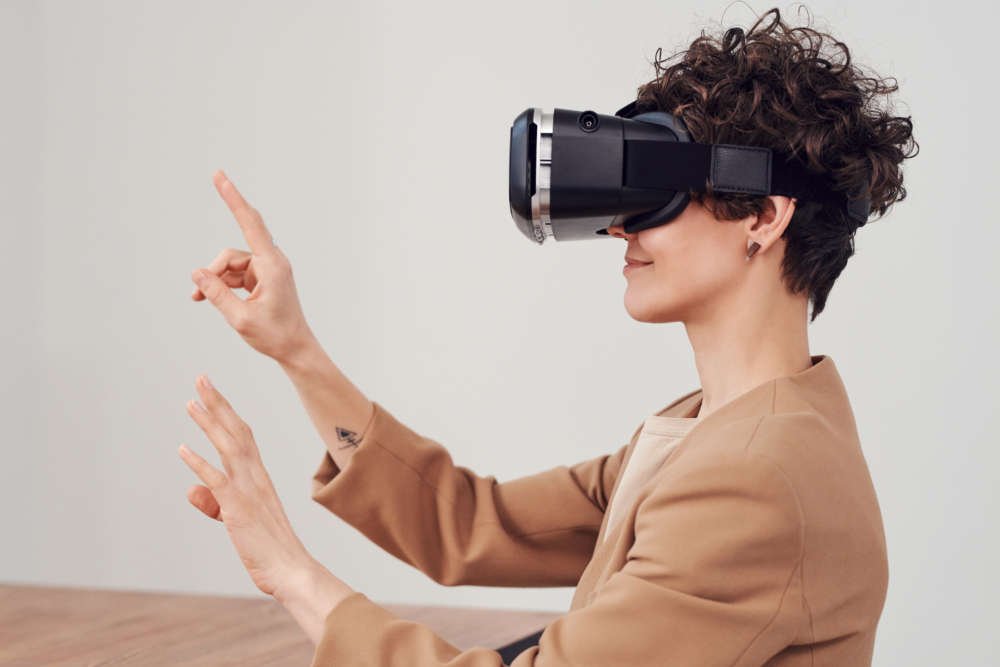 Person using virtual reality goggles, representing hybrid events in finance - Global Banking & Finance Review