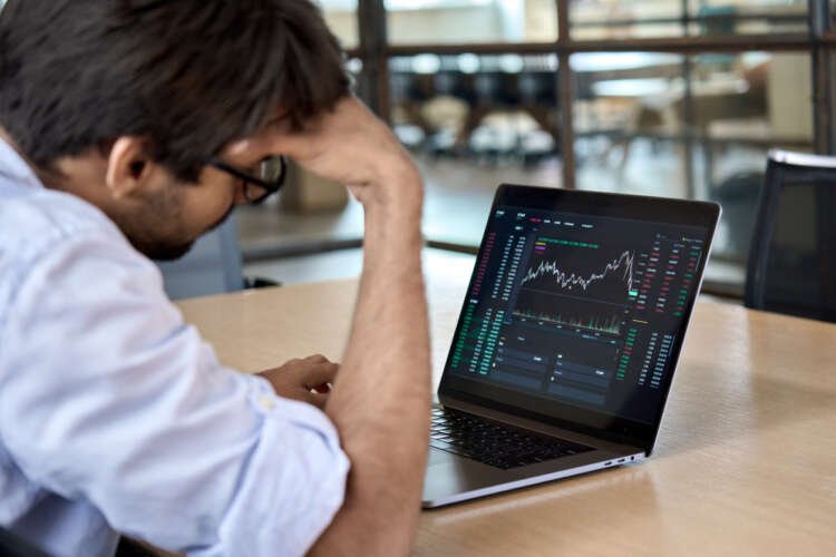 Stressed trader analyzing stock market volatility during winter - Global Banking & Finance Review