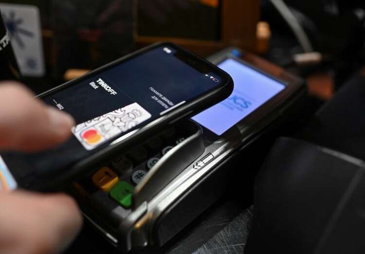 Customer using mobile wallet at a cafe, highlighting tech in finance amid Russia's software inclusion talks - Global Banking & Finance Review