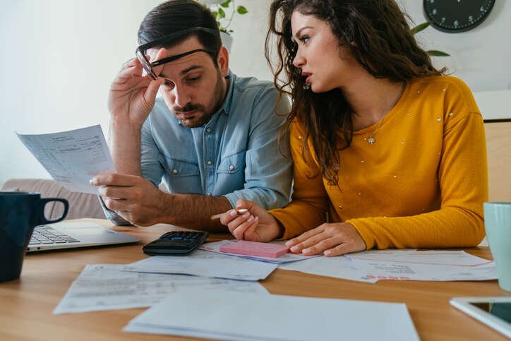 Person reviewing financial documents and tax forms for settling tax debt - Global Banking & Finance Review