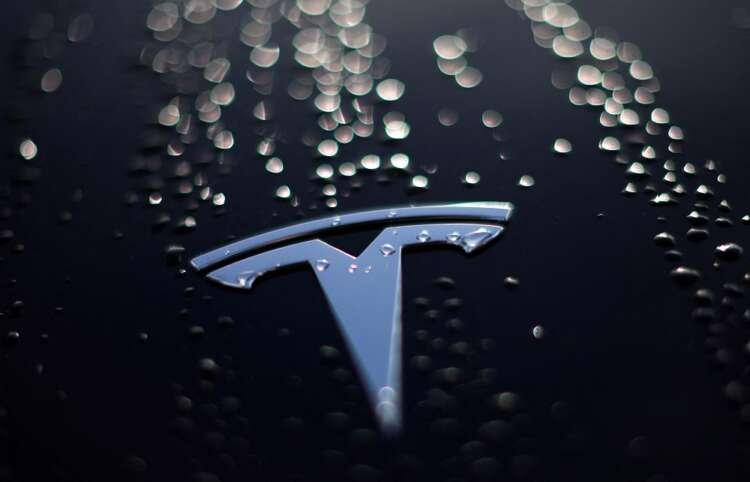 Raindrops on a used Tesla electric car's bonnet, highlighting EV battery test significance - Global Banking & Finance Review