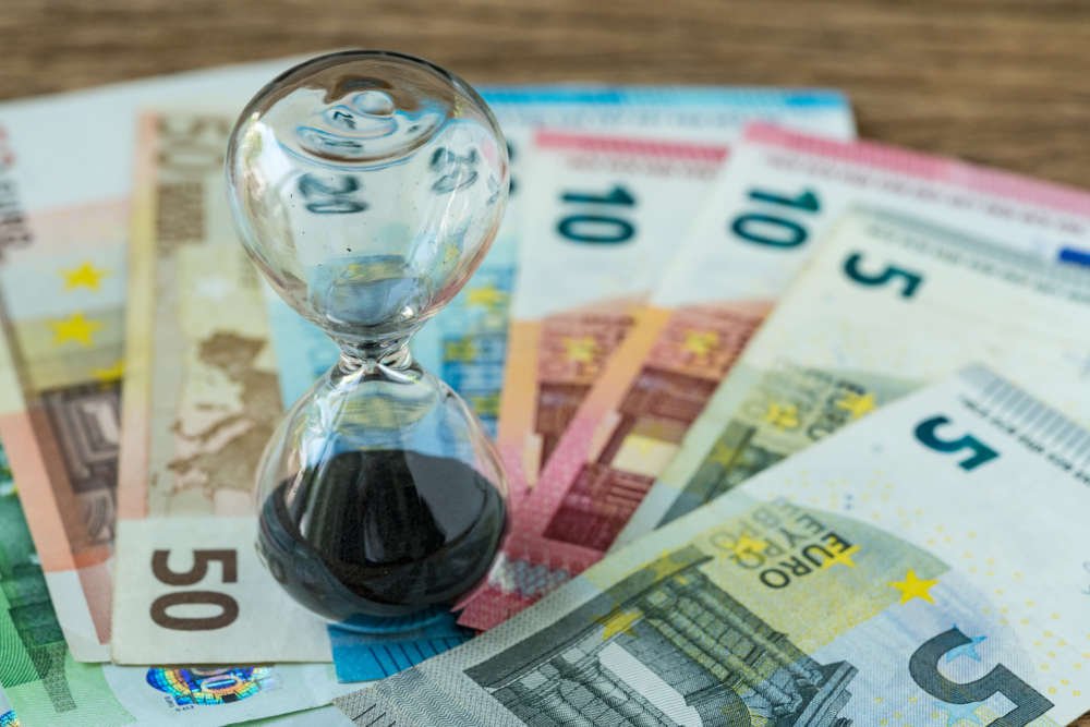 Hourglass symbolizing long-term investment strategy with Euro banknotes - Global Banking & Finance Review