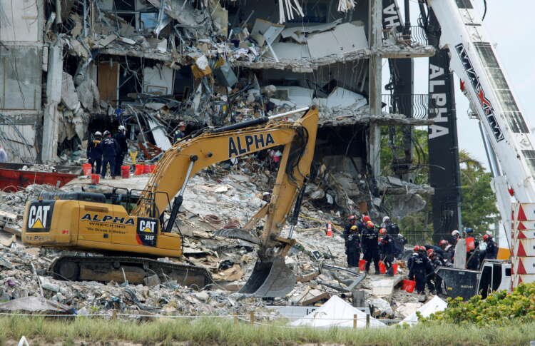 Emergency workers conduct search and rescue missions at the site of a partially collapsed residential building in Surfside