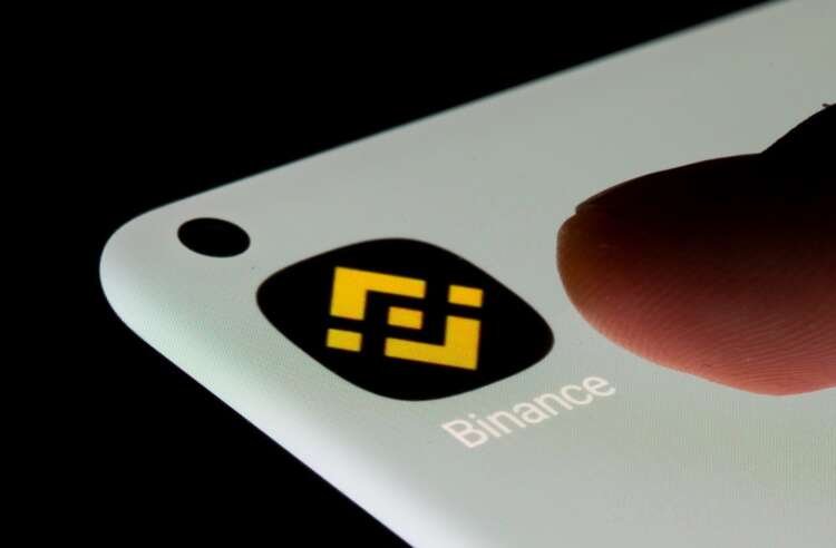 Binance logo with a backdrop of cryptocurrency trading charts - Global Banking & Finance Review