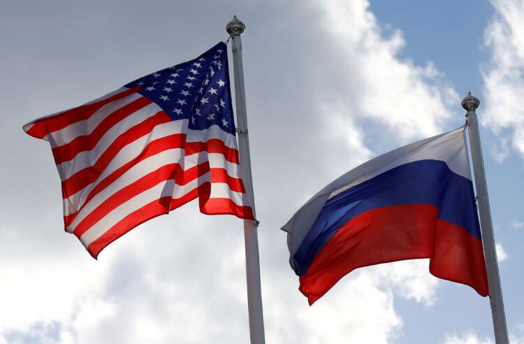FILE PHOTO: FILE PHOTO: Russian and U.S. state flags fly near a factory in Vsevolozhsk