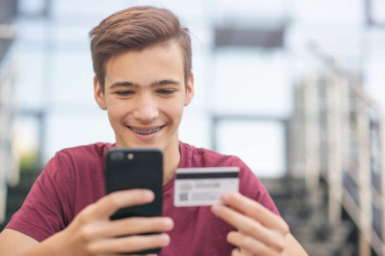 Young man using a credit card and smartphone for online shopping - Gen Z Banking Revolution - Global Banking & Finance Review