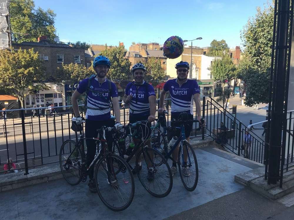 Three Vizolution staff cyclists celebrating after completing their charity ride - Global Banking & Finance Review