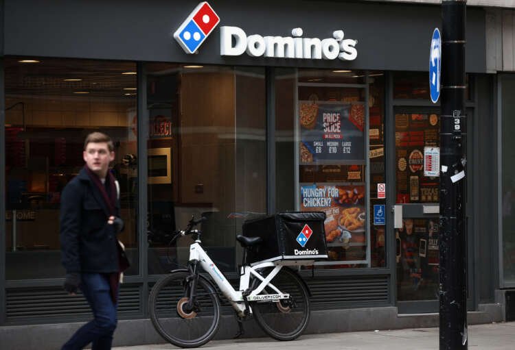 Exterior of a Domino's Pizza restaurant in London amidst news of tech investments impacting profits - Global Banking & Finance Review