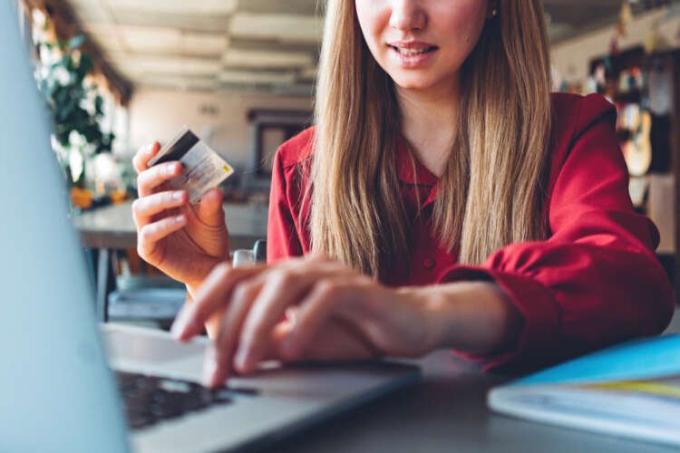 Woman using a credit card for online payment, showcasing Open Banking - Global Banking & Finance Review