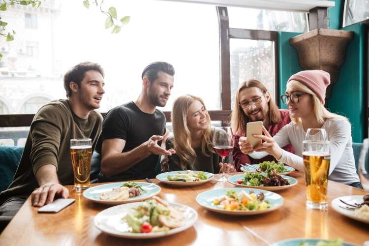Cheerful friends enjoying non-alcoholic beer in a cafe, highlighting Germany's drinking trend - Global Banking & Finance Review