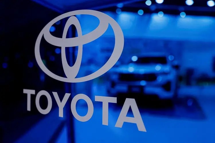 Toyota logo with financial charts, illustrating profit drop amid cooling demand - Global Banking & Finance Review