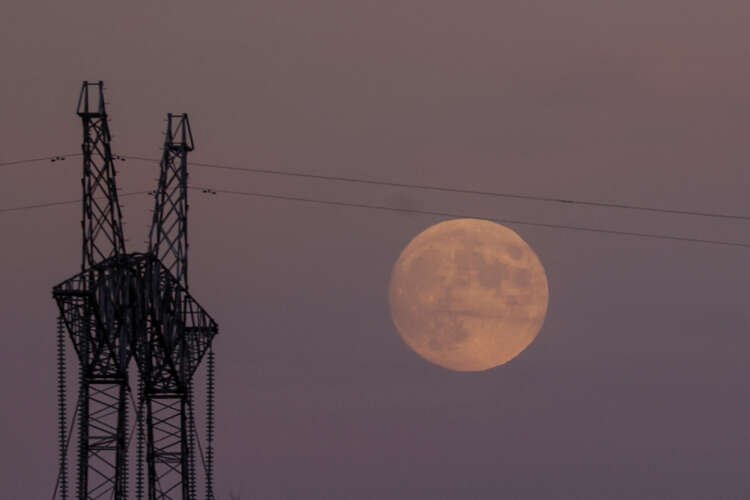 Full moon rises behind electricity pylon during the 'Beaver blood moon' eclipse - Global Banking & Finance Review