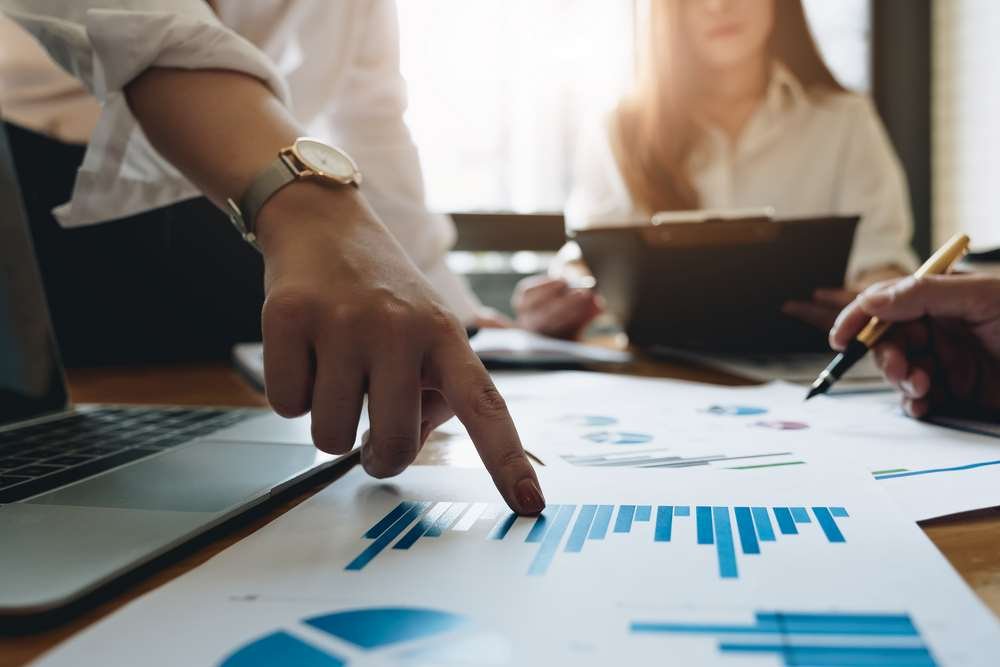 Group of employees discussing workplace dynamics and cliques - Global Banking & Finance Review