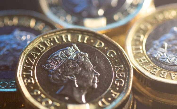Illustration of British pound coins representing currency fluctuations - Global Banking & Finance Review