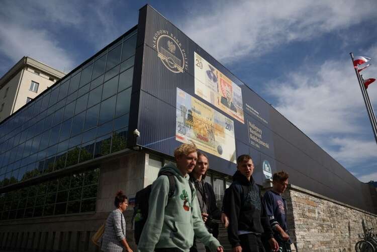 People walking in front of the Polish Central Bank building, symbolizing interest rate decisions - Global Banking & Finance Review