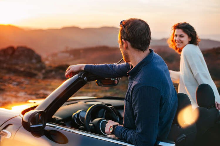 Couple enjoying a scenic drive in a convertible car, emphasizing the joy of open-top driving - Global Banking & Finance Review