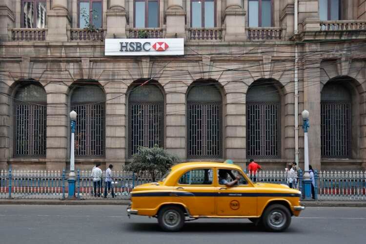 Yellow ambassador taxi in front of HSBC bank building, symbolizing India's financial growth - Global Banking & Finance Review