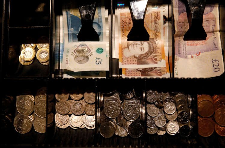 Pound Sterling notes and coins in a cash register, reflecting currency stability - Global Banking & Finance Review