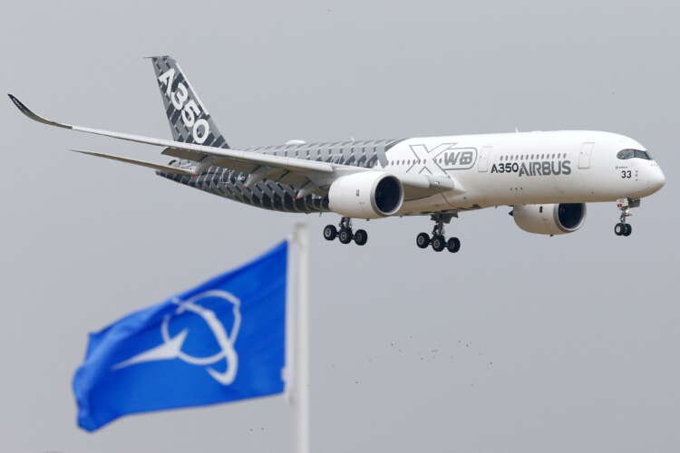 Airbus A350 jetliner landing at Paris Air Show amidst Boeing flags - Global Banking & Finance Review