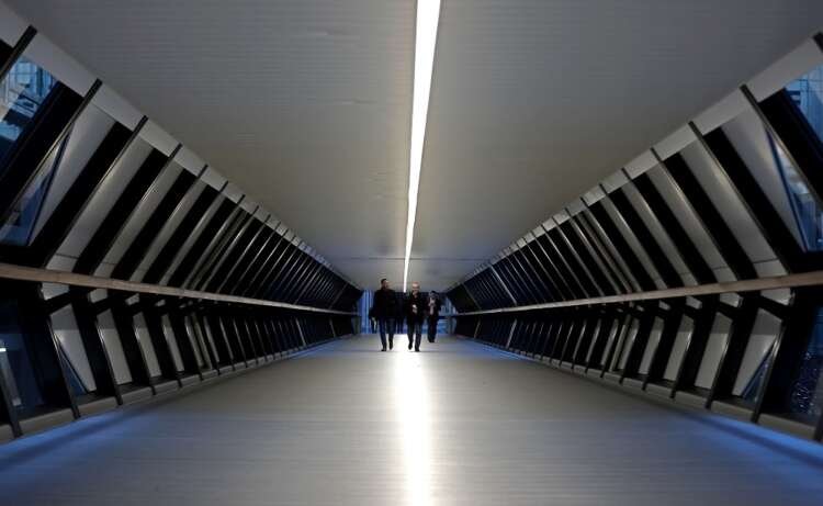 People walking through Crossrail Place Bridge in Canary Wharf, London - Global Banking & Finance Review