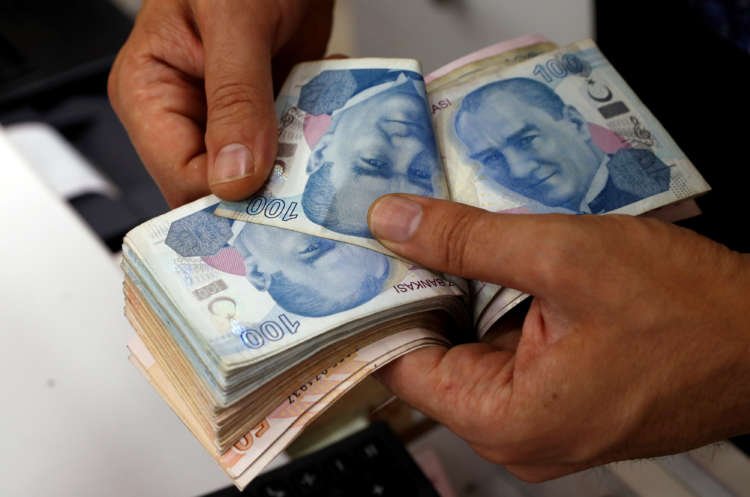 A money changer counts Turkish lira banknotes, reflecting investor interest in Turkish markets - Global Banking & Finance Review