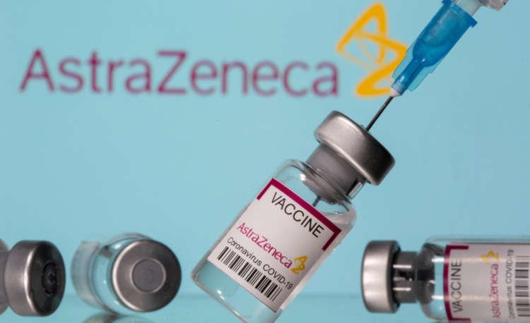 FILE PHOTO: Vials labelled “Astra Zeneca COVID-19 Coronavirus Vaccine” and a syringe are seen in front of a displayed AstraZeneca logo in this illustration photo