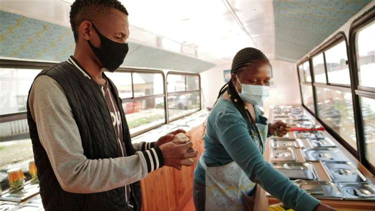 Sanele Msibi assists a customer inside the Skhaftin bus in Johannesburg, South Africa. May 18, 2021. Thomson Reuters Foundation/Kim Harrisberg