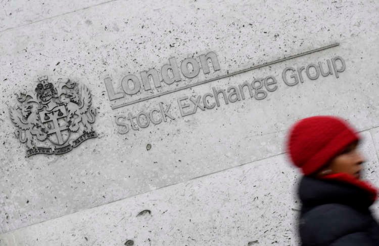 A woman walking past the London Stock Exchange, highlighting FTSE 250 performance - Global Banking & Finance Review