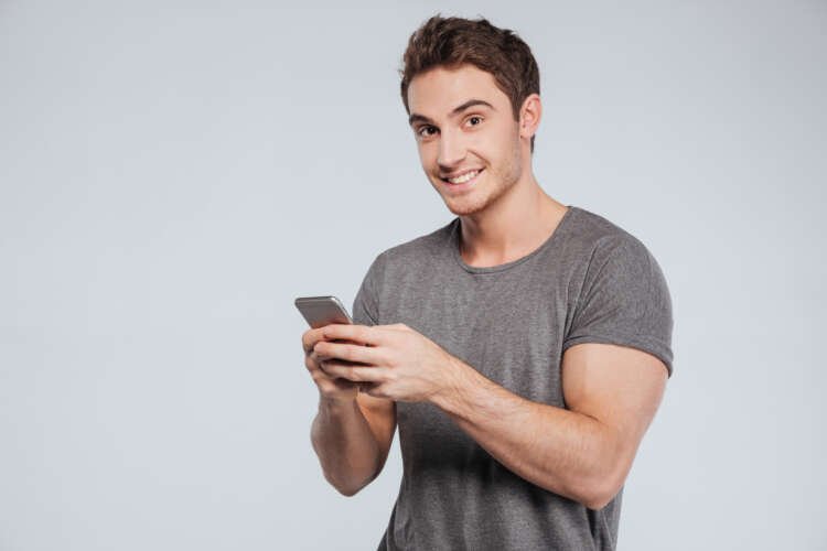 Portrait of a happy casual man using smartphone