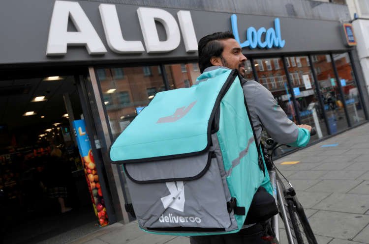 FILE PHOTO: Abdelaziz Abdou, a Deliveroo delivery rider, poses with a bag of Aldi groceries, London