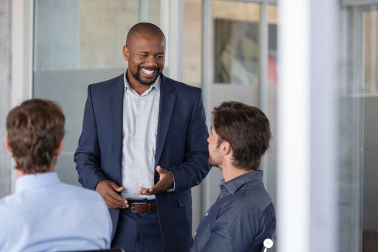 Mature business man smiling during a meeting, symbolizing entrepreneurial risk-taking - Global Banking & Finance Review