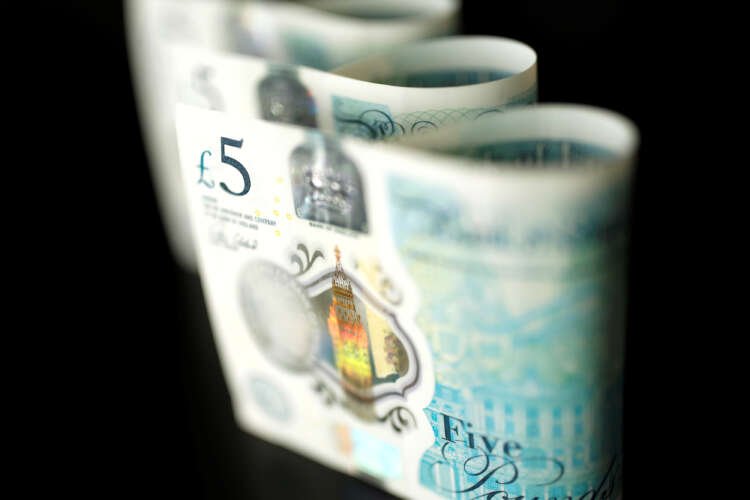 British five pound banknotes representing currency stability amid reopening delays - Global Banking & Finance Review
