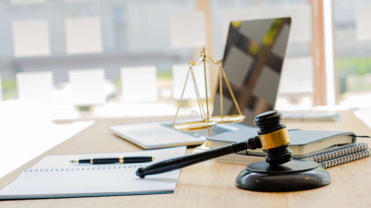 Judge’s gavel, notebook, and laptop symbolize legal insights on FCA's insurance reforms - Global Banking & Finance Review