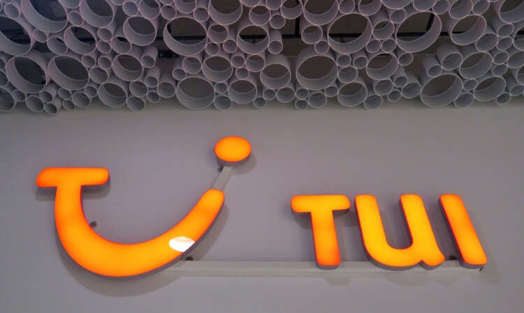 The TUI AG logo outside a branch office, symbolizing summer travel demand - Global Banking & Finance Review
