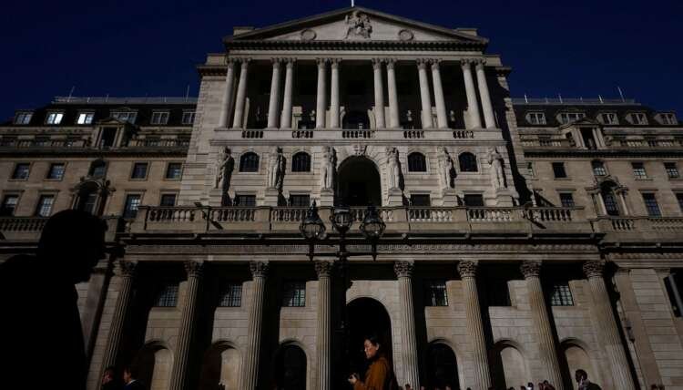 People walking outside the Bank of England, symbolizing economic discussions on interest rates - Global Banking & Finance Review
