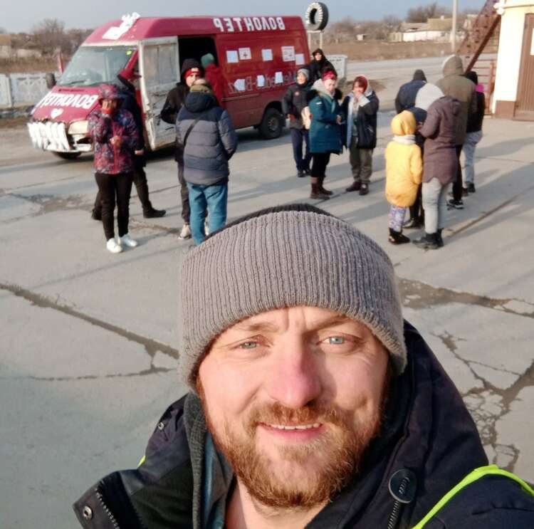 Mykhailo Puryshev poses for a selfie photo in front of a car as he evacuates people fleeing Russia’s invasion of Ukraine, in Zaporizhzhia