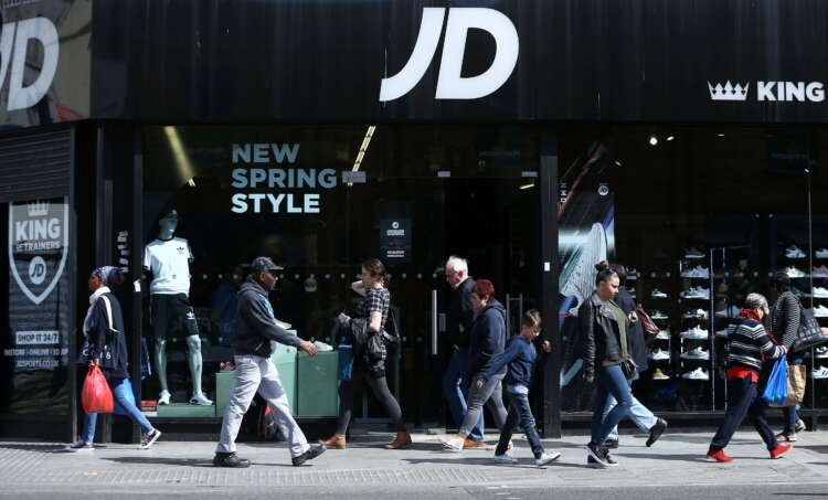 FILE PHOTO: People pass a JD Sports store in London