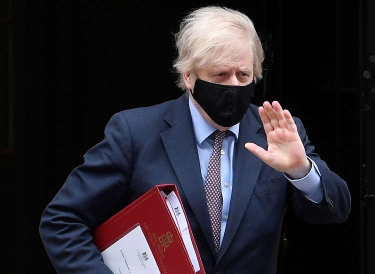 Britain’s PM Johnson walks outside Downing Street in London