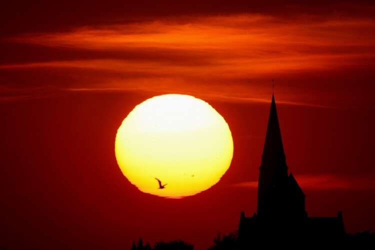 A church silhouetted by the sunset amidst a heatwave impacting Europe - Global Banking & Finance Review