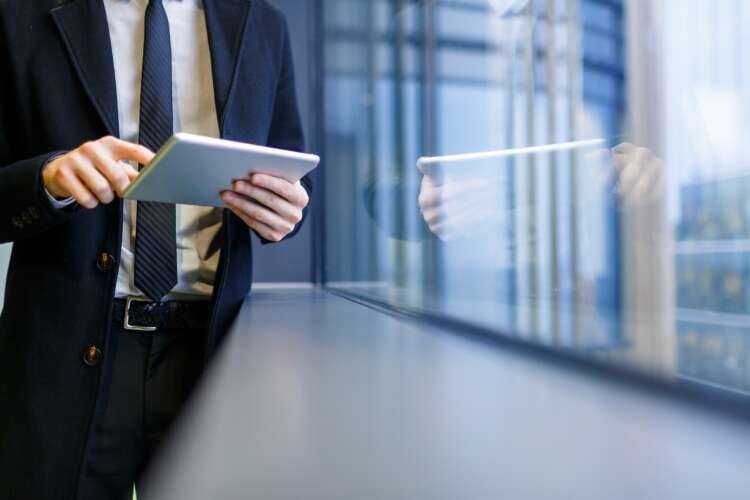 Businessman networking with digital tools, reflecting treasurers' banking relationship strategies - Global Banking & Finance Review